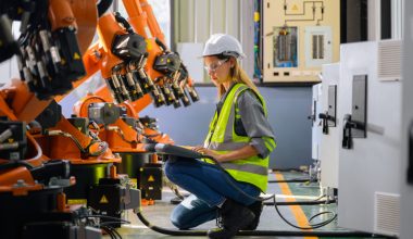 Female engineer worker working with robotic machine automation at factory, Female technician with smart technology at industry, Female worker checking and controlling parts of robotic machine