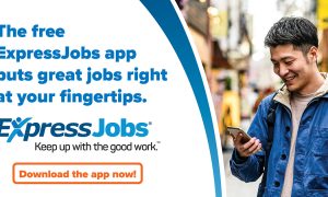 Promotional image for the ExpressJobs app showing a man looking at his smartphone, alongside text and a logo advertising the app. A man is standing slightly turned to the right as he looks at his smartphone. He is wearing a blue jacket over a beige hoodie and carrying a black backpack. Text in image says The free ExpressJobs app puts great jobs right at your fingertips. Download the app now!