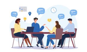 Four people discussing at a table with icons like a calendar, light bulb, and laptop. There are comment bubbles in the space above them.