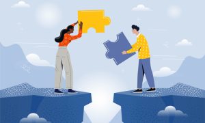 Two people on opposite sides of a gap holding large puzzle pieces, symbolizing collaboration and bridging roles, with a sky and mountain backdrop.