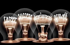 Photo of light bulb with shining fibers in shapes of CAREER , SUCCESS, DEVELOPMENT, GROWTH concept words isolated on black background