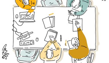 Illustration: top-down view of four adults (men and women) seated around a table collaborating, wearing casual tops in yellow, teal, and neutral tones, writing on papers with pens and laptops nearby.